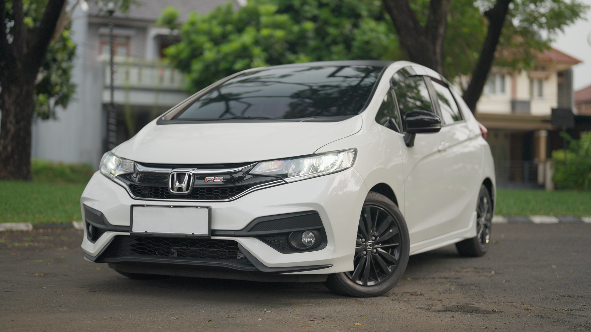 A stylish white Honda RS car parked in a serene residential neighborhood.