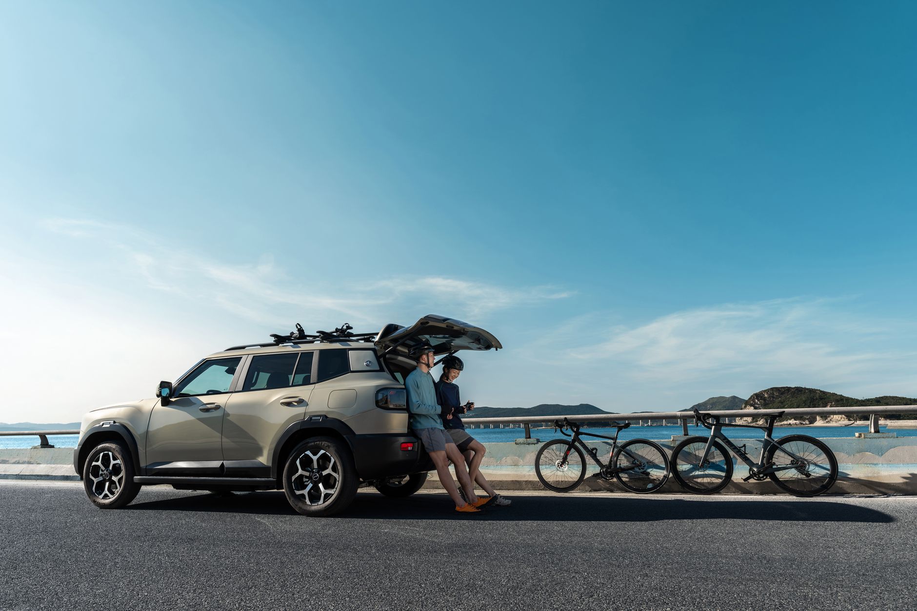 Modern SUV parked on a coastal road with bicycles, ideal for a scenic adventure.