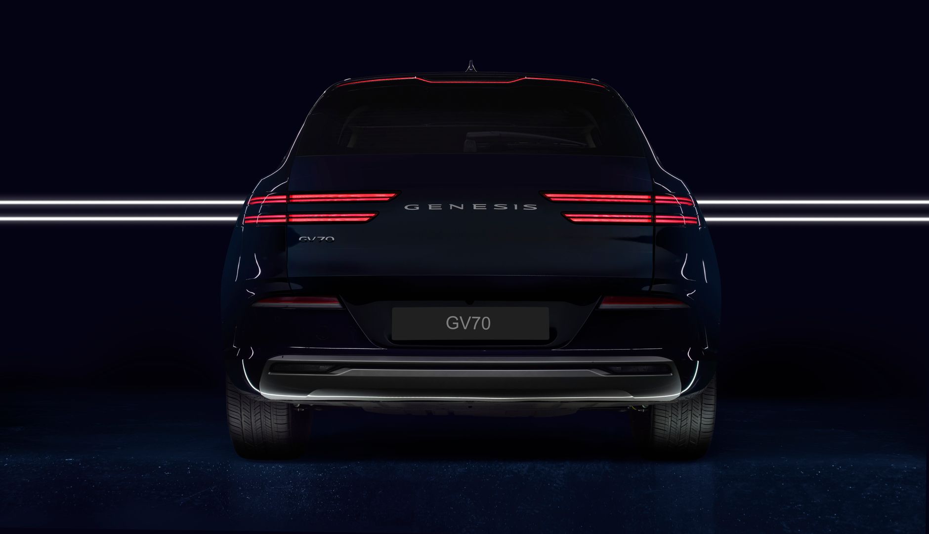 Rear view of a Genesis GV70 luxury SUV with illuminated lights, captured in a studio setting.