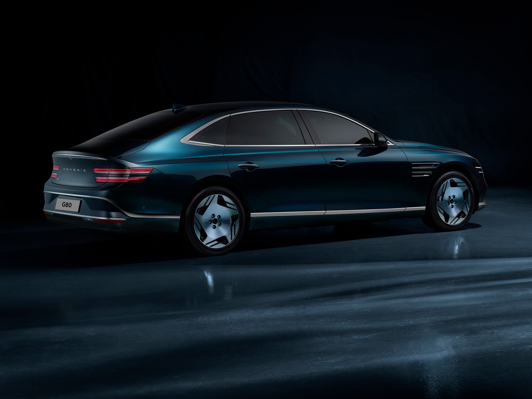 Stylish rear view of a Genesis G80 electric car in a dimly lit studio setting.