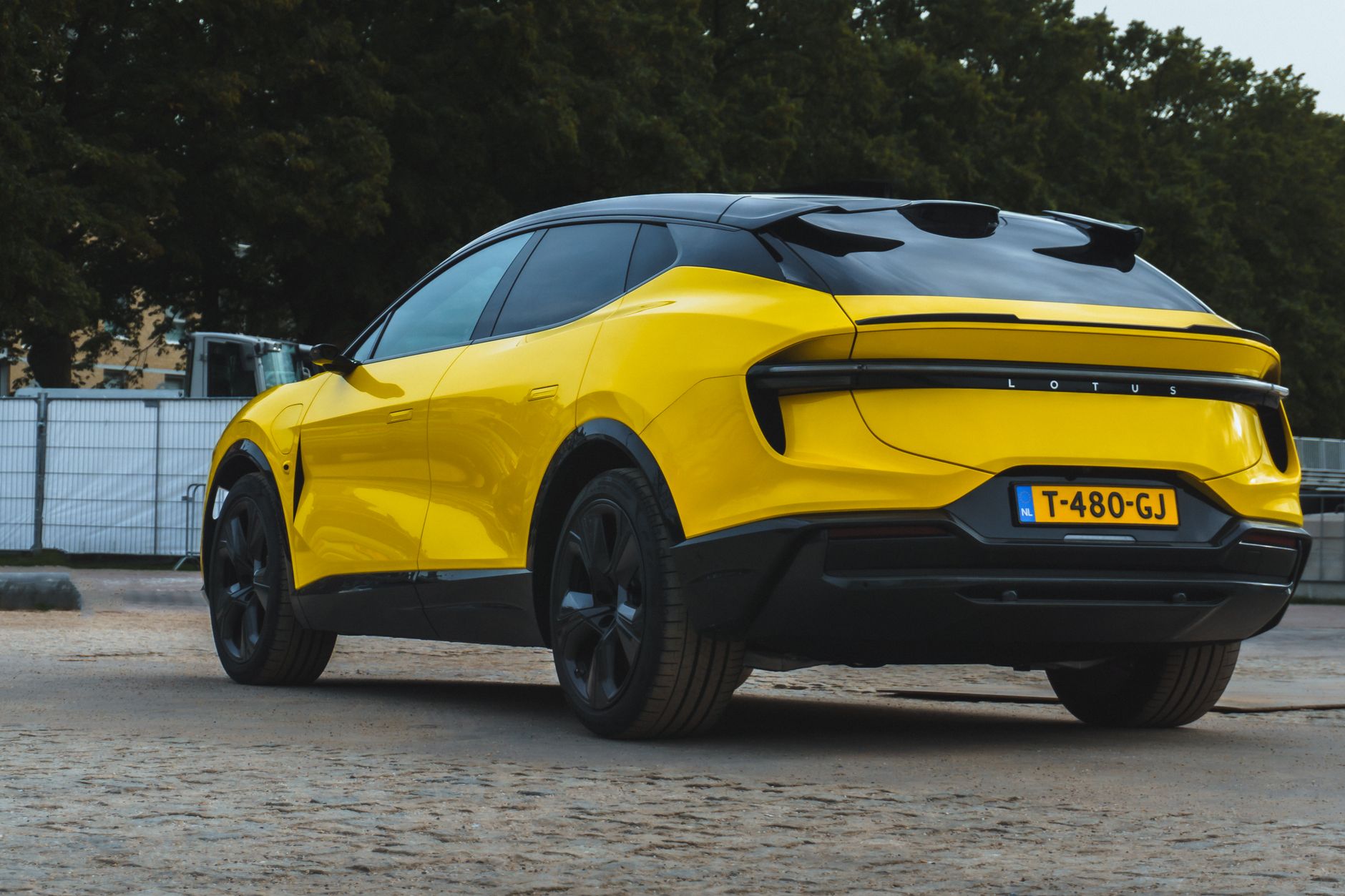 Yellow sports SUV parked outdoors with a modern design, showcasing sleek curves and glossy finish.