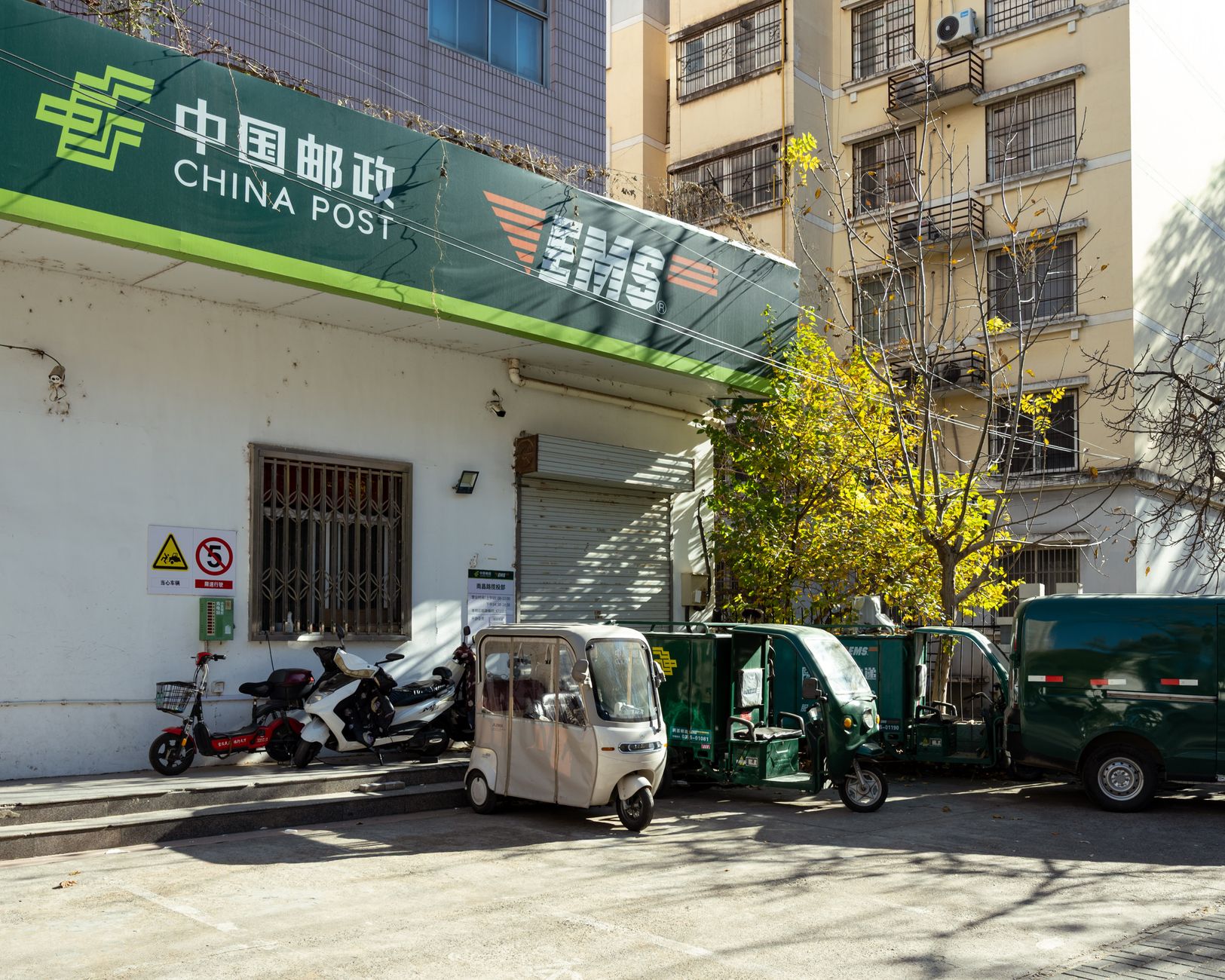 China Post office facade with delivery vehicles in Luoyang, Henan, China.