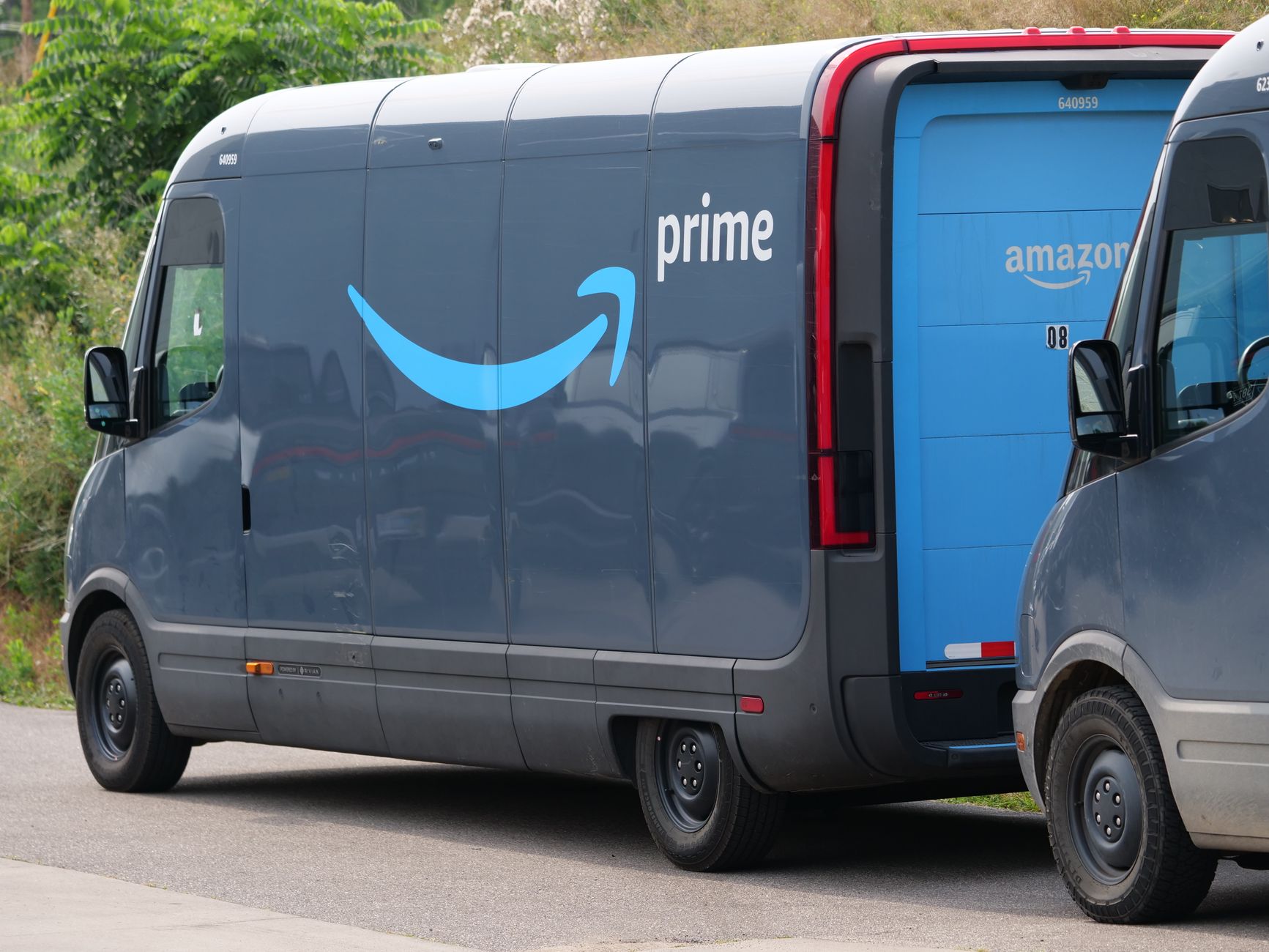 Blue electric delivery vans parked outdoors, highlighting modern urban logistics.