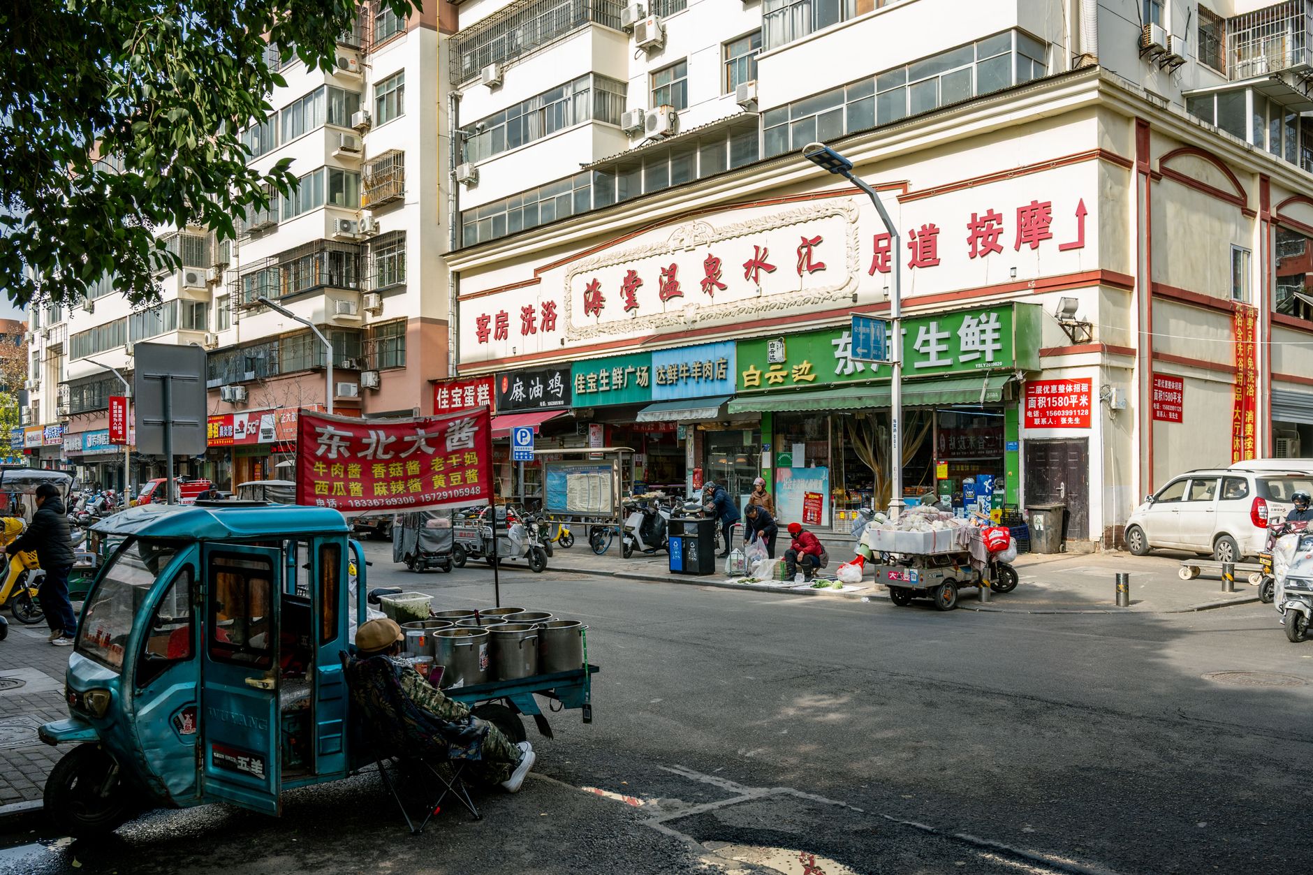 Street view capturing daily life and activities in Luoyang, China, showcasing local businesses and urban traffic.