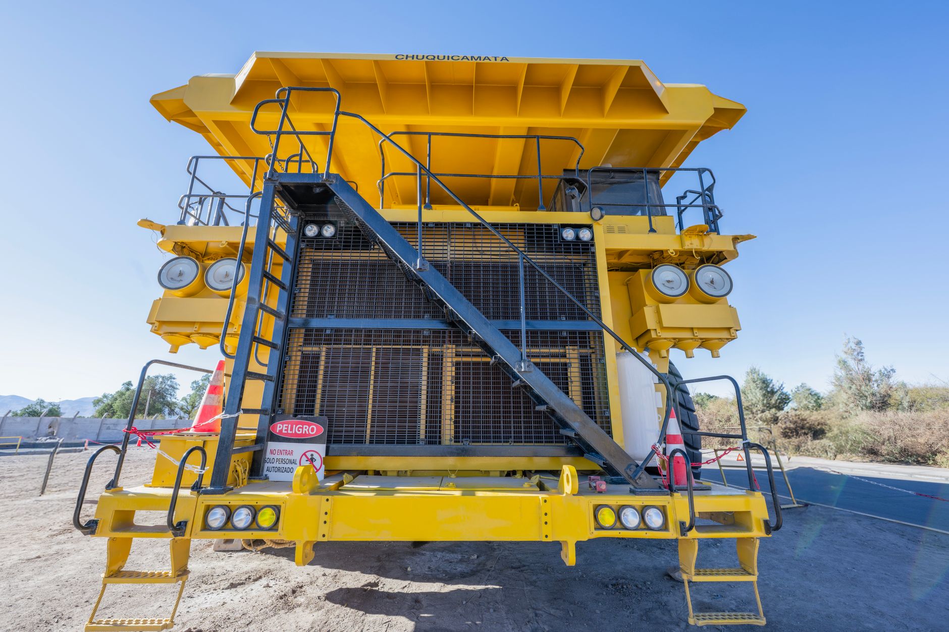 Front view of a large yellow mining truck in Chuquicamata mine, Calama, Chile, on a sunny day.