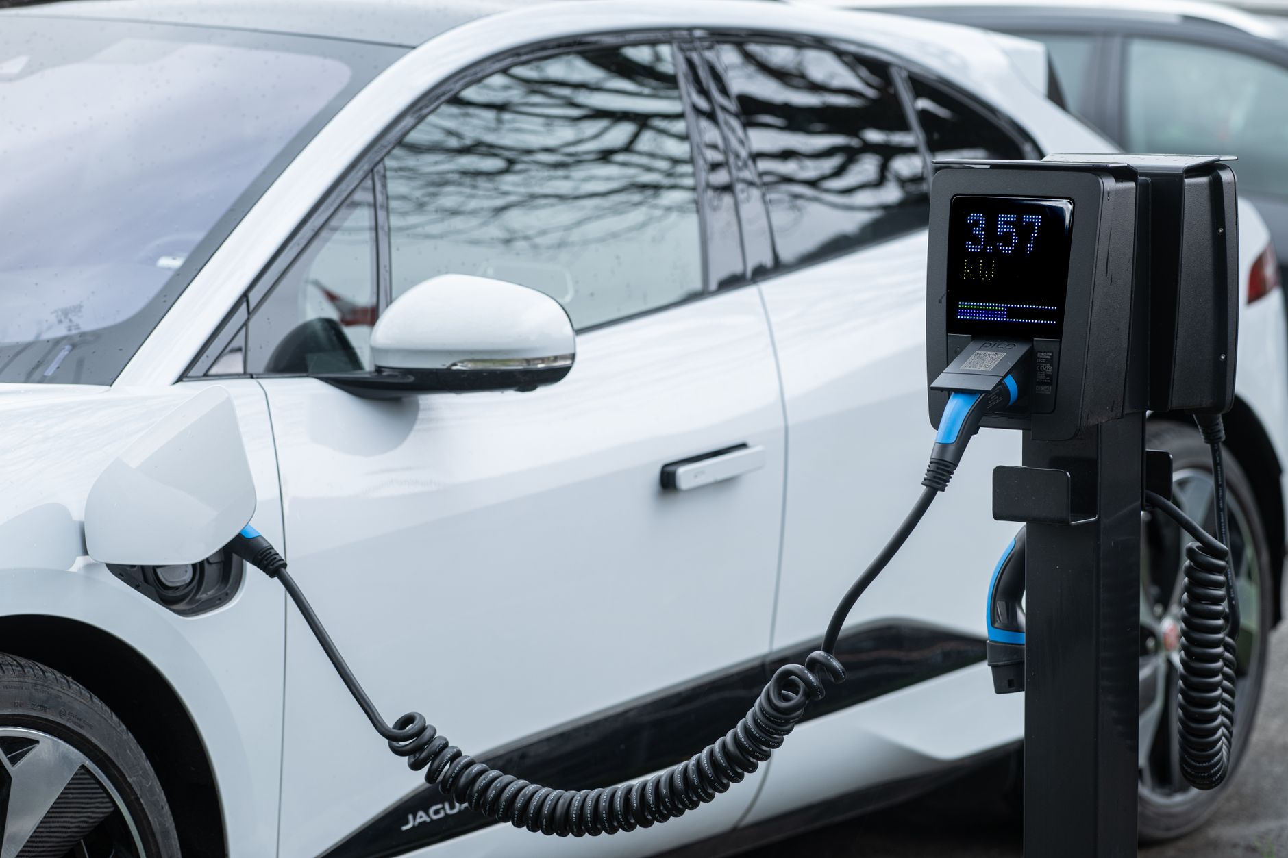 Close-up of an electric vehicle charging at a station, showcasing energy-efficient technology.