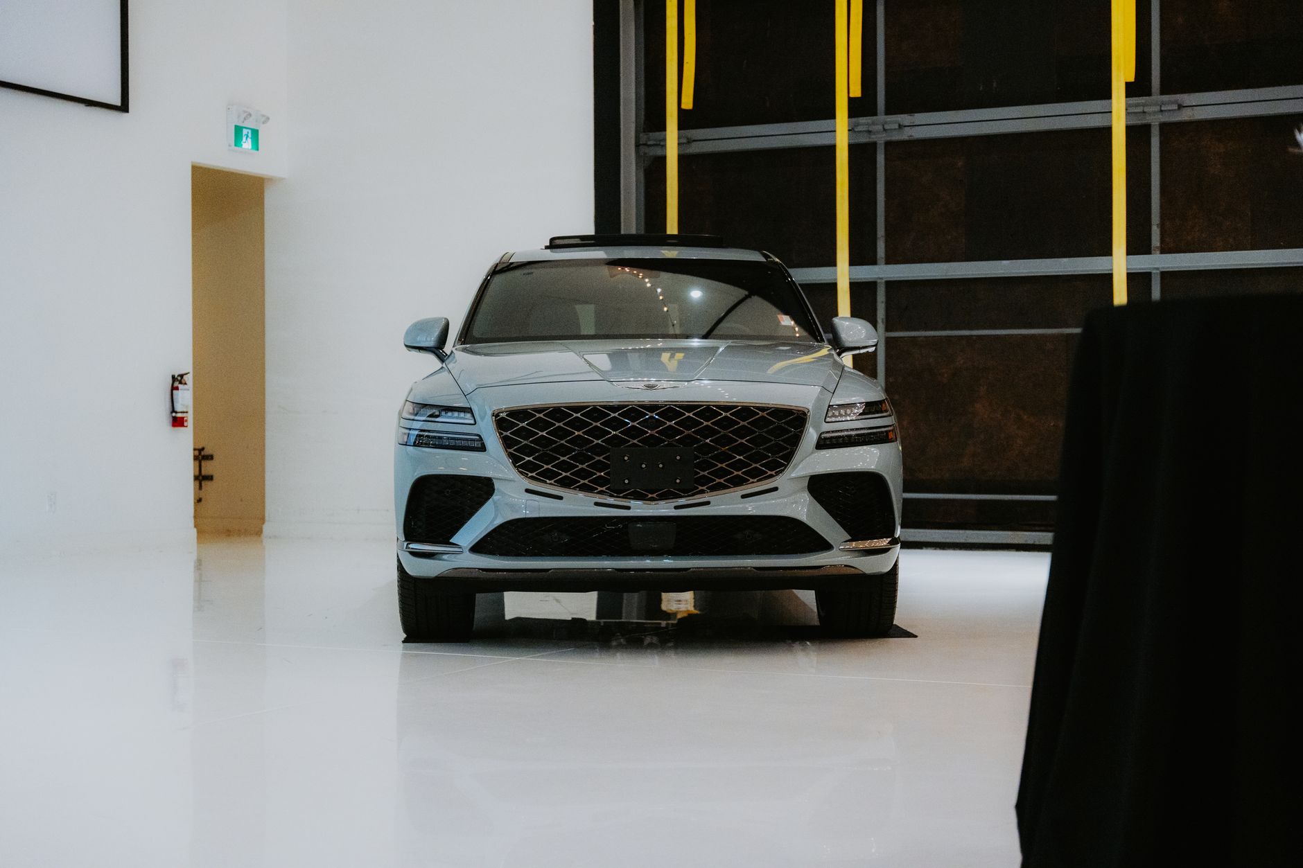Front view of a luxury SUV displayed in a sleek indoor showroom with minimalist decor